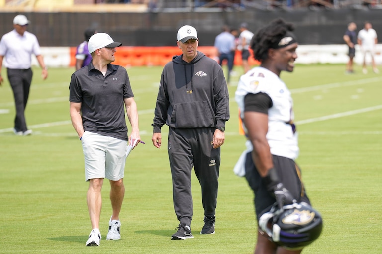 Baltimore Ravens offensive coordinator Todd Monken, center, walks to the podium area of the field to take questions from reporters following the team’s organized team activities at the Under Armour Performance Center in Owings Mills, Md. on Tuesday, June 3, 2025.