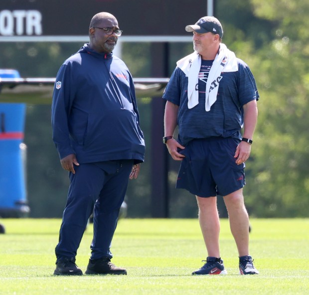 New England Patriots defensive coordinator Terrell Williams, left, speaks to a trainer during the second day of training camp on July 24. (Mark Stockwell/Boston Herald)