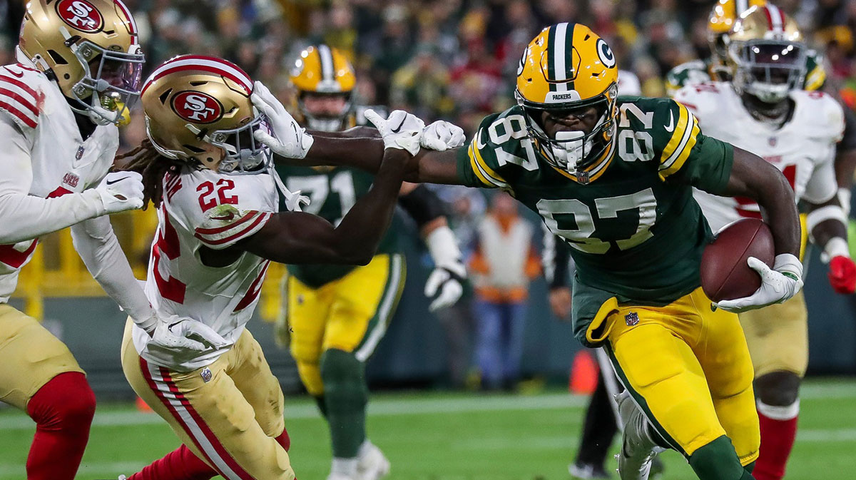Green Bay Packers wide receiver Romeo Doubs (87) stiff-arms San Francisco 49ers cornerback Isaac Yiadom (22) as he runs after making a catch on Sunday, November 24, 2024, at Lambeau Field in Green Bay, Wis. The Packers won the game, 38-10.