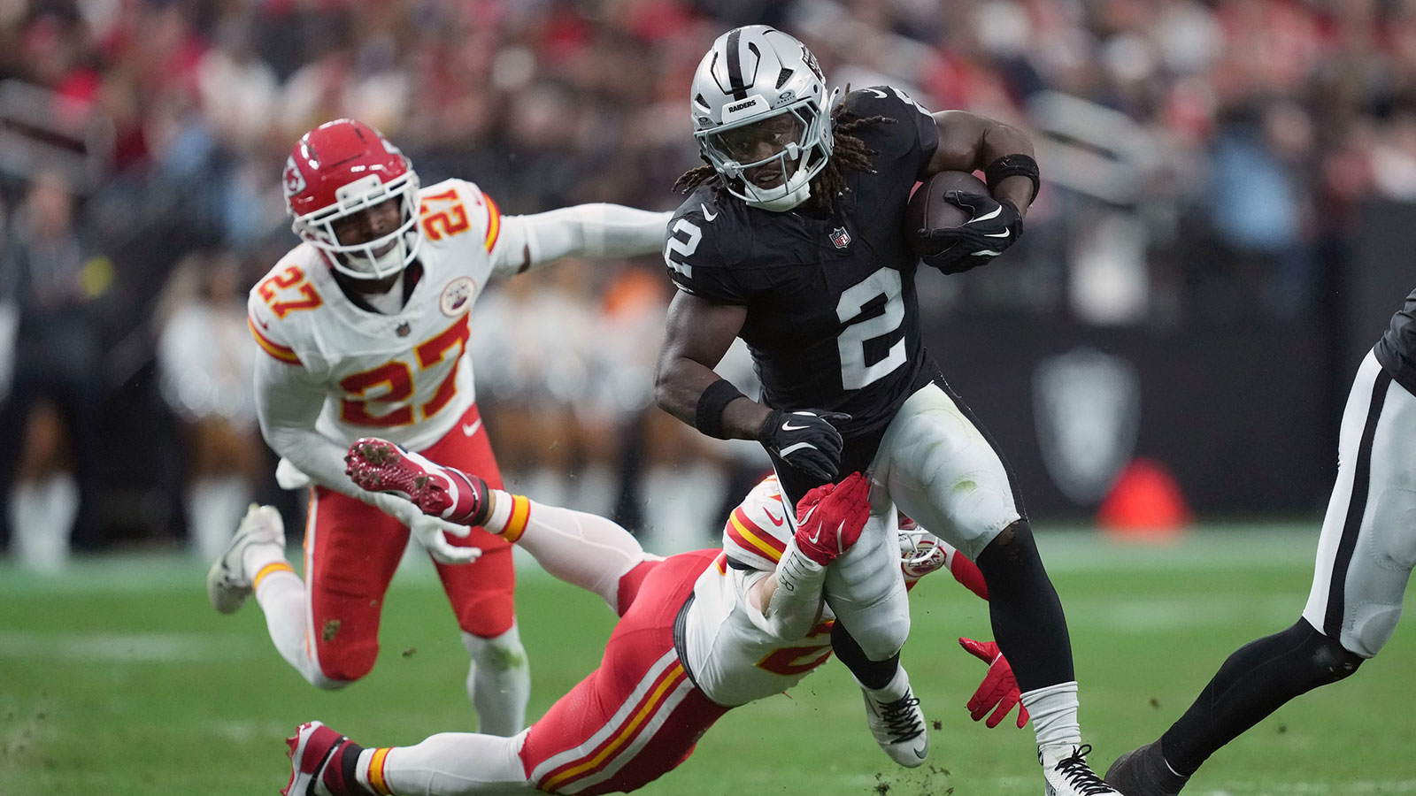 Las Vegas Raiders running back Ashton Jeanty (2) carries the ball against Kansas City Chiefs linebacker Drue Tranquill (23) in the first half at Allegiant Stadium.