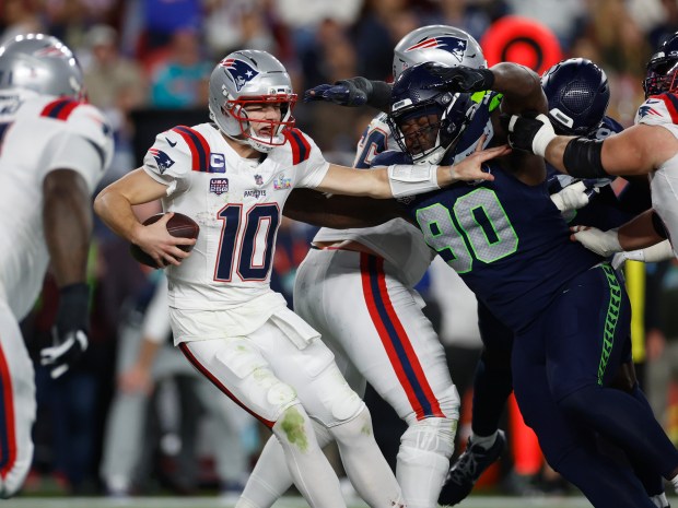 New England Patriots quarterback Drake Maye (10) avoids a sack by Seattle Seahawks' Jarran Reed (90) in the third quarter of Super Bowl 60 at Levi's Stadium in Santa Clara, Calif., on Sunday, Feb. 8, 2026. (Nhat V. Meyer/Bay Area News Group)