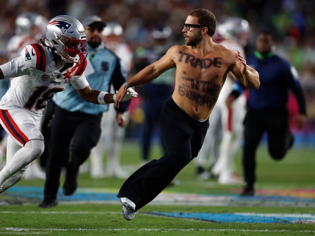 New England Patriots' Kyle Williams (18) chases after a man who ran on the field during their game against the Seattle Seahawks in the fourth quarter of Super Bowl 60 at Levi's Stadium in Santa Clara, Calif., on Sunday, Feb. 8, 2026. (Nhat V. Meyer/Bay Area News Group)