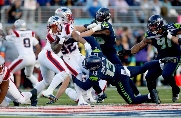 New England Patriots' TreVeyon Henderson (32) is tackled for a loss by Seattle Seahawks' Ernest Jones IV (13) in the first quarter of Super Bowl 60 at Levi's Stadium in Santa Clara, Calif., on Sunday, Feb. 8, 2026. (Nhat V. Meyer/Bay Area News Group)
