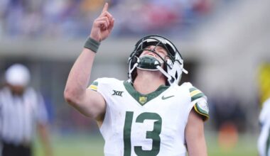 Baylor Bears quarterback #13 celebrates on the field, pointing upward after a big play while wearing a white and green uniform.