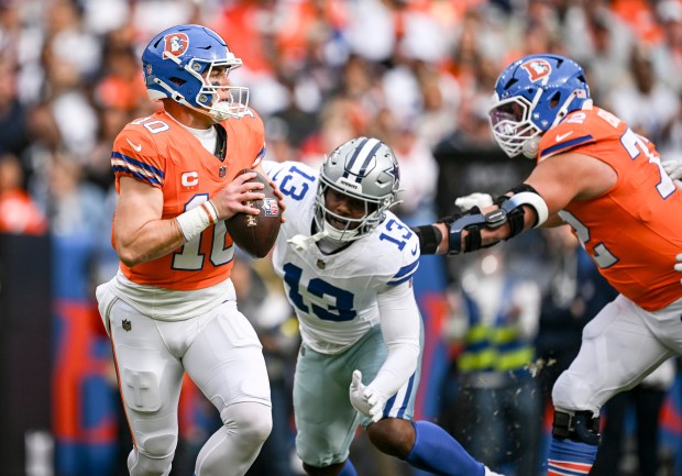 Bo Nix (10) of the Denver Broncos rolls out as Garett Bolles (72) blocks Dante Fowler Jr. (13) of the Dallas Cowboys during the first quarter at Empower Field at Mile High in Denver on Sunday, Oct. 26, 2025. (Photo by AAron Ontiveroz/The Denver Post)