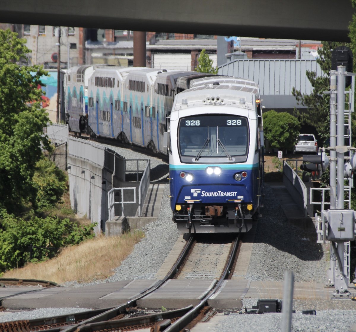 Blue and white commuter train approaches, led by cab car