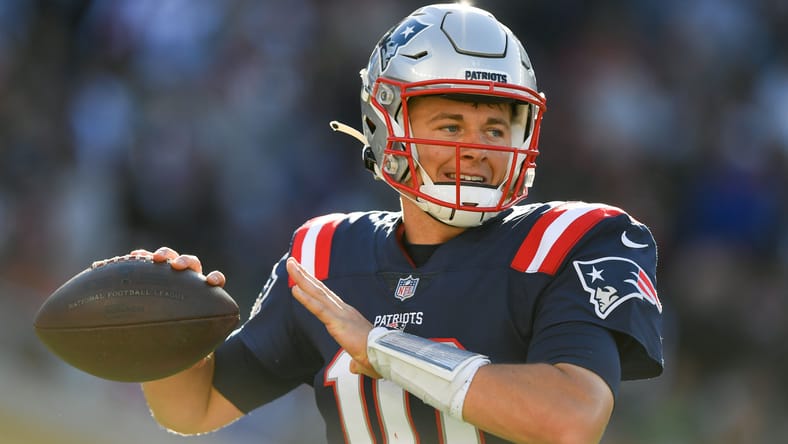 Mac Jones throws a football on the Patriots sideline before a game against the Jets. Vikings Mac Jones trade.