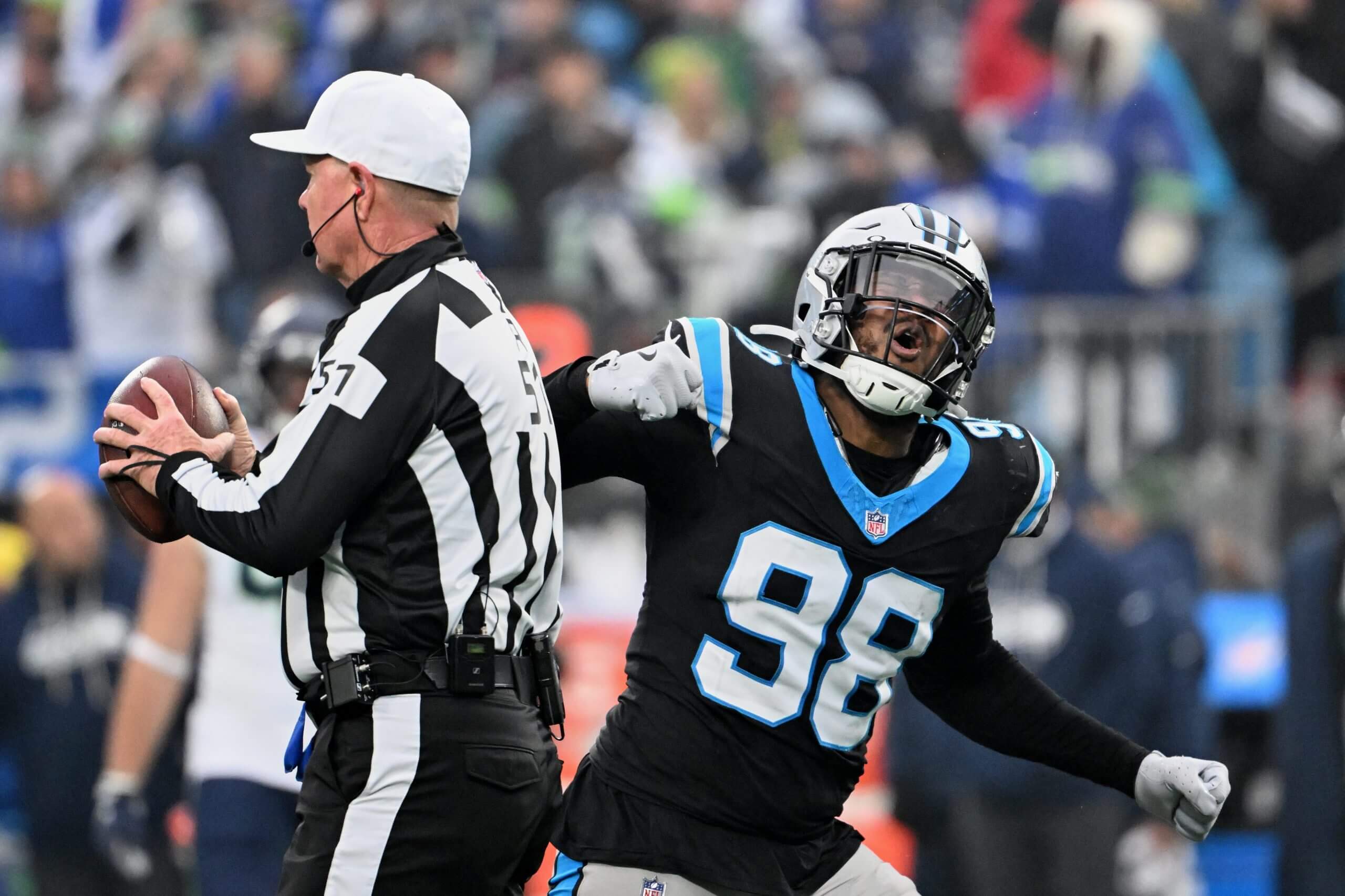 Carolina Panthers linebacker D.J. Wonnum (98) tosses the ball to referee Carl Cheffers (51) and reacts after sacking Seattle Seahawks quarterback Sam Darnold during the fourth quarter at Bank of America Stadium.