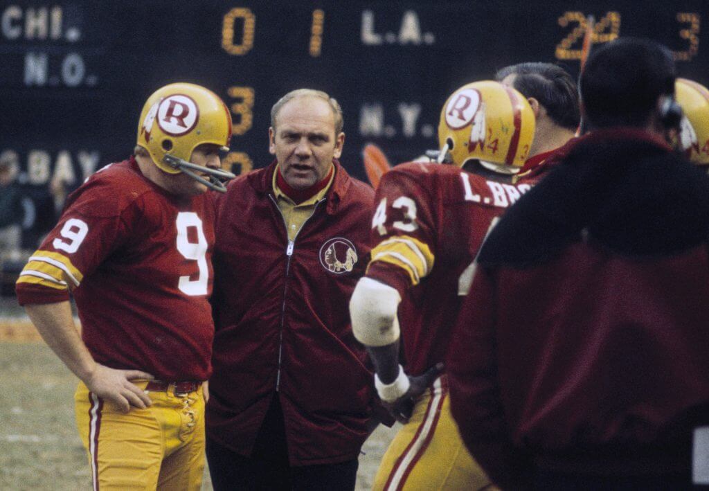 Sonny Jurgensen meets with Washington coach Bill Austin on the sideline during a game in 1970.