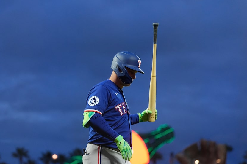Texas Rangers designated hitter Joc Pederson walks to the dugout after flying out in foul...