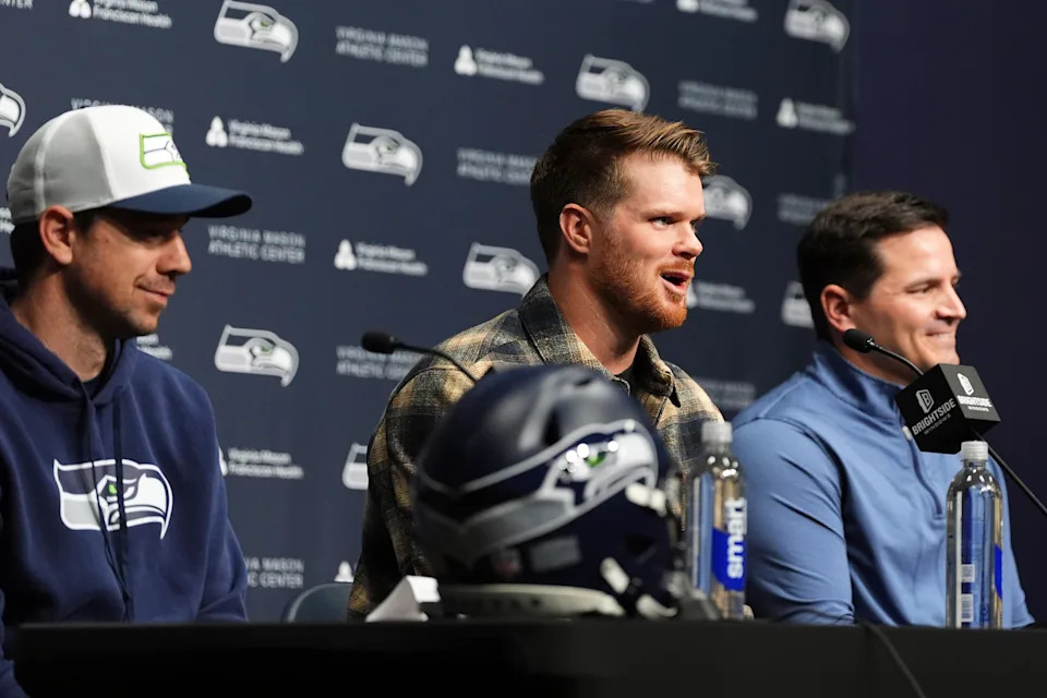 Seattle Seahawks quarterback Sam Darnold, center, speaks as offensive coordinator Klint Kubiak, left, and head coach Mike Macdonald, right, listen during an introductory news conference Thursday, March 13, 2025, at the NFL football team's facilities in Renton, Wash. (AP Photo/Lindsey Wasson)