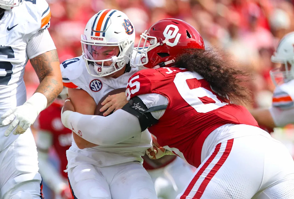 Sep 20, 2025; Norman, Oklahoma, USA; Oklahoma Sooners defensive lineman Jayden Jackson (65) tackles Auburn Tigers quarterback Jackson Arnold (11) during the first half at Gaylord Family-Oklahoma Memorial Stadium. Mandatory Credit: Kevin Jairaj-Imagn Images