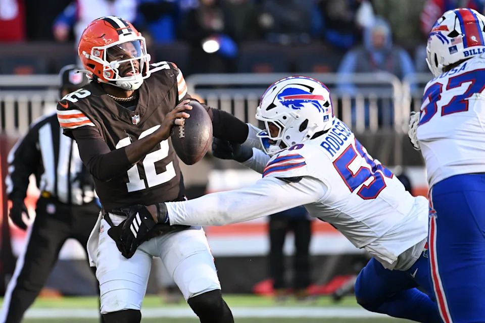 Dec 21, 2025; Cleveland, Ohio, USA; Cleveland Browns quarterback Shedeur Sanders (12) is pressures by. Buffalo Bills defensive end Greg Rousseau (50) during the second half at Huntington Bank Field. Mandatory Credit: Ken Blaze-Imagn Images