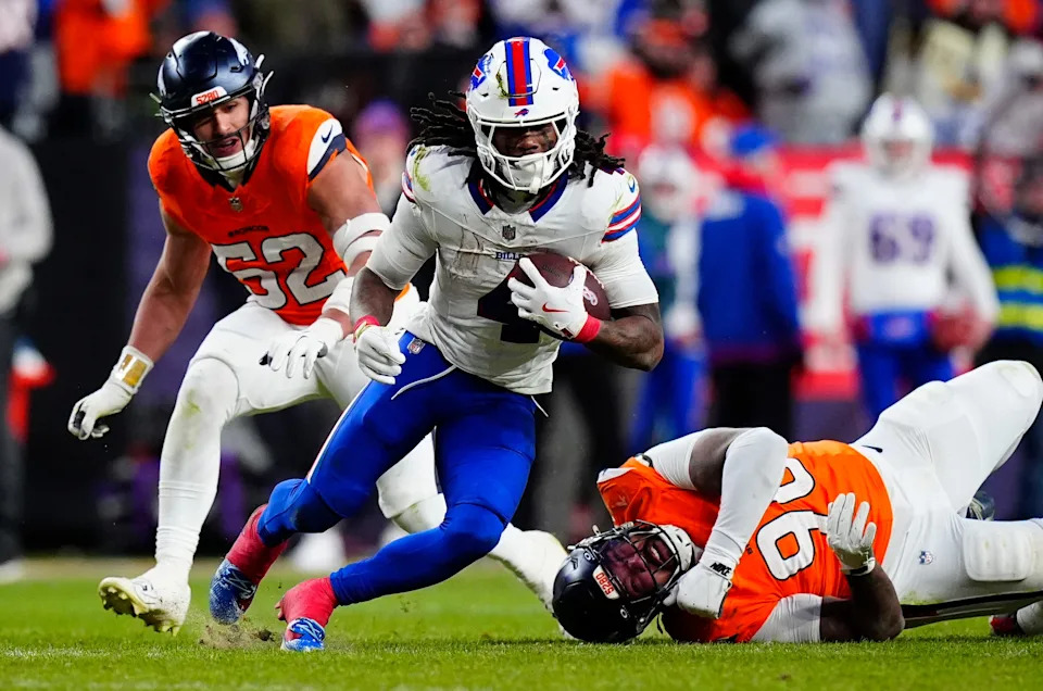 Jan 17, 2026; Denver, CO, USA; Buffalo Bills running back James Cook III (4) runs against Denver Broncos linebacker Jonah Elliss (52) and defensive end Eyioma Uwazurike (96) during the fourth quarter of an AFC Divisional Round playoff game at Empower Field at Mile High. Mandatory Credit: Ron Chenoy-Imagn Images