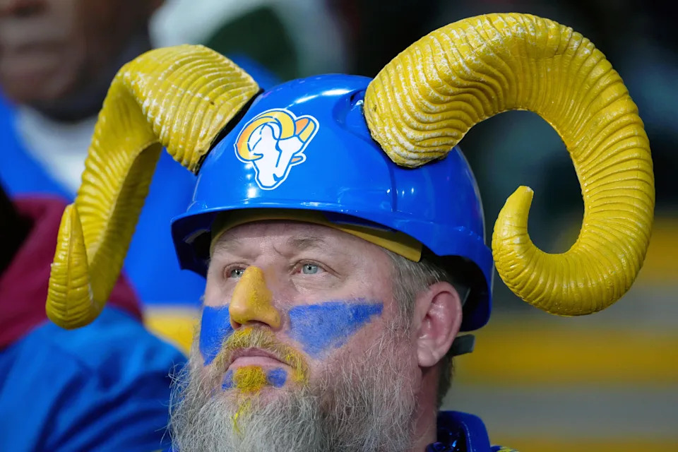 A Los Angeles Rams fan wears a helmet with ram horns.