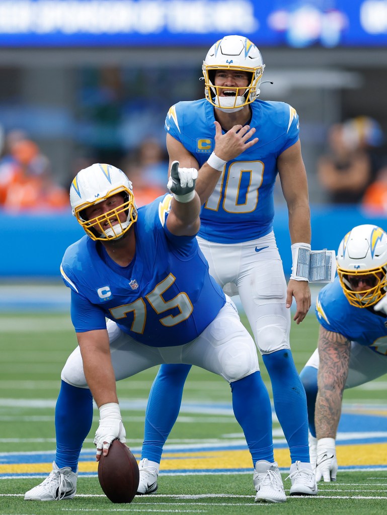 Bradley Bozeman and Justin Herbert on the field during an NFL game.