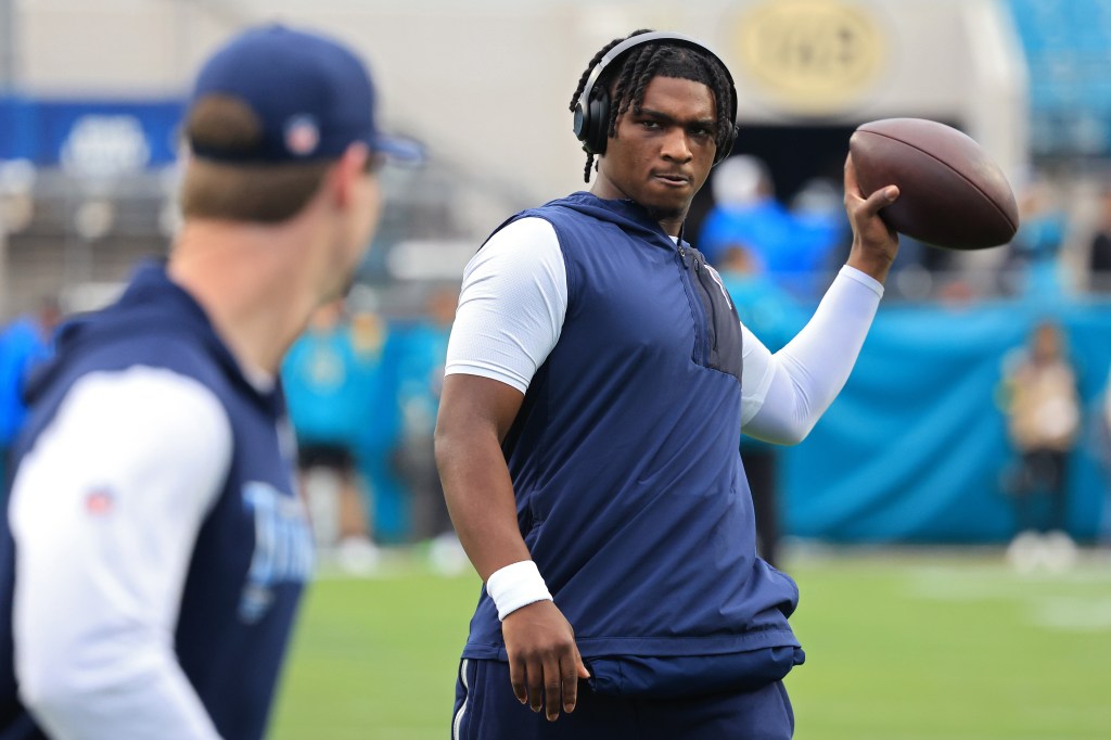 Cam Ward #1 of the Tennessee Titans warms up, holding a football.