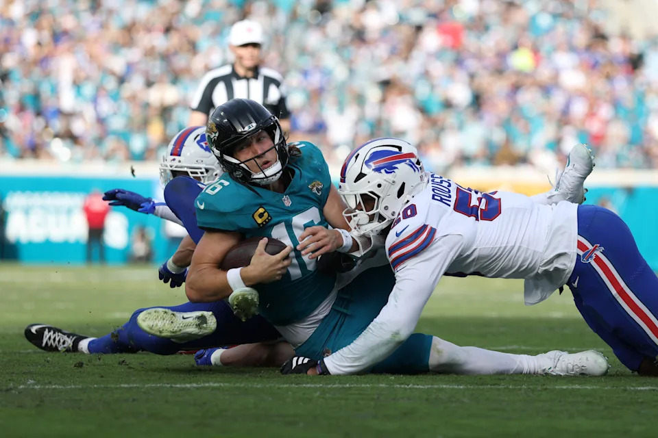 Jan 11, 2026; Jacksonville, FL, USA; Jacksonville Jaguars quarterback Trevor Lawrence (16) is tackled by Buffalo Bills defensive end Greg Rousseau (50) during the second half in an AFC Wild Card Round game at EverBank Stadium. Mandatory Credit: Nathan Ray Seebeck-Imagn Images