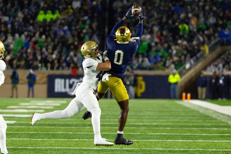 Nov 8, 2025; South Bend, Indiana, USA; Notre Dame Fighting Irish wide receiver Malachi Fields (0) makes a catch as Navy Midshipmen linebacker Adam Klenk (49) defends during the first half at Notre Dame Stadium. Michael Caterina-Imagn Images
