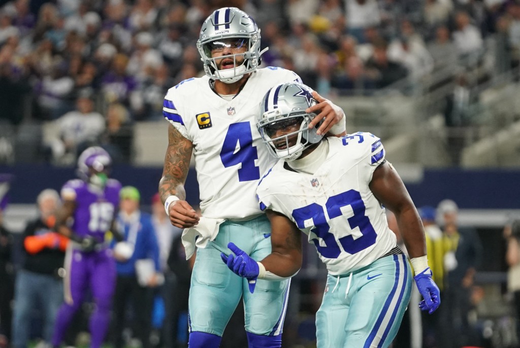 Dallas Cowboys running back Javonte Williams (33) and quarterback Dak Prescott (4) celebrating a touchdown.