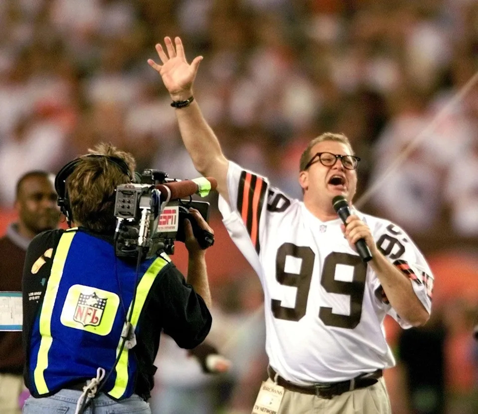 Television star and Cleveland native Drew Carey leads the crowd in a version of "Cleveland Rocks'' prior to the start of a game between the Cleveland Browns and Pittsburgh Steelers at Cleveland Browns Stadium in 1999.