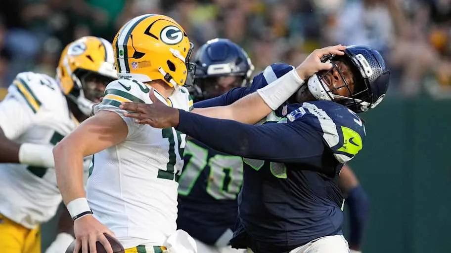 Green Bay Packers quarterback Taylor Elgersma (19) stiff arms Seattle Seahawks linebacker Jared Ivey