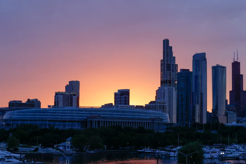 A general overall exterior view of Soldier Field, home of the Chicago Bears, and the downtown skyline at sunset on June 07, 2024 