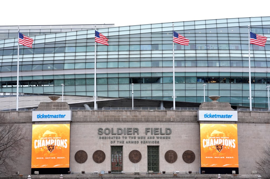 Soldier Field entrance with US flags and "2025 NFC North Champions" banners for the Chicago Bears.