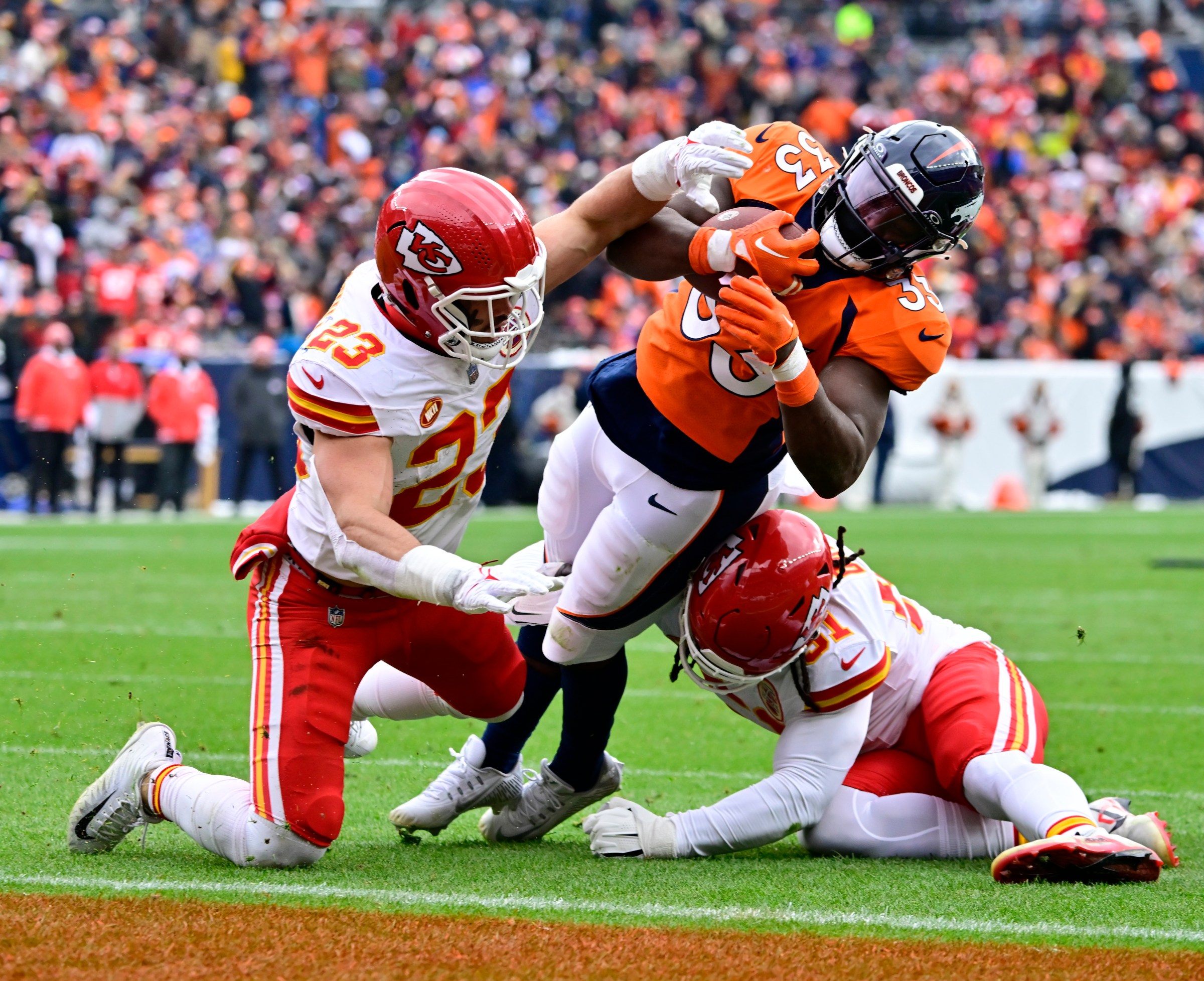 DENVER, CO - OCTOBER 29: Denver Broncos running back Javonte Williams (33) scores a touchdown against Kansas City Chiefs linebacker Drue Tranquill (23) and Kansas City Chiefs defensive end Mike Danna (51) in the first quarter at Empower Field at Mile High October 29, 2023. (Photo by Andy Cross/MediaNews Group/The Denver Post via Getty Images)