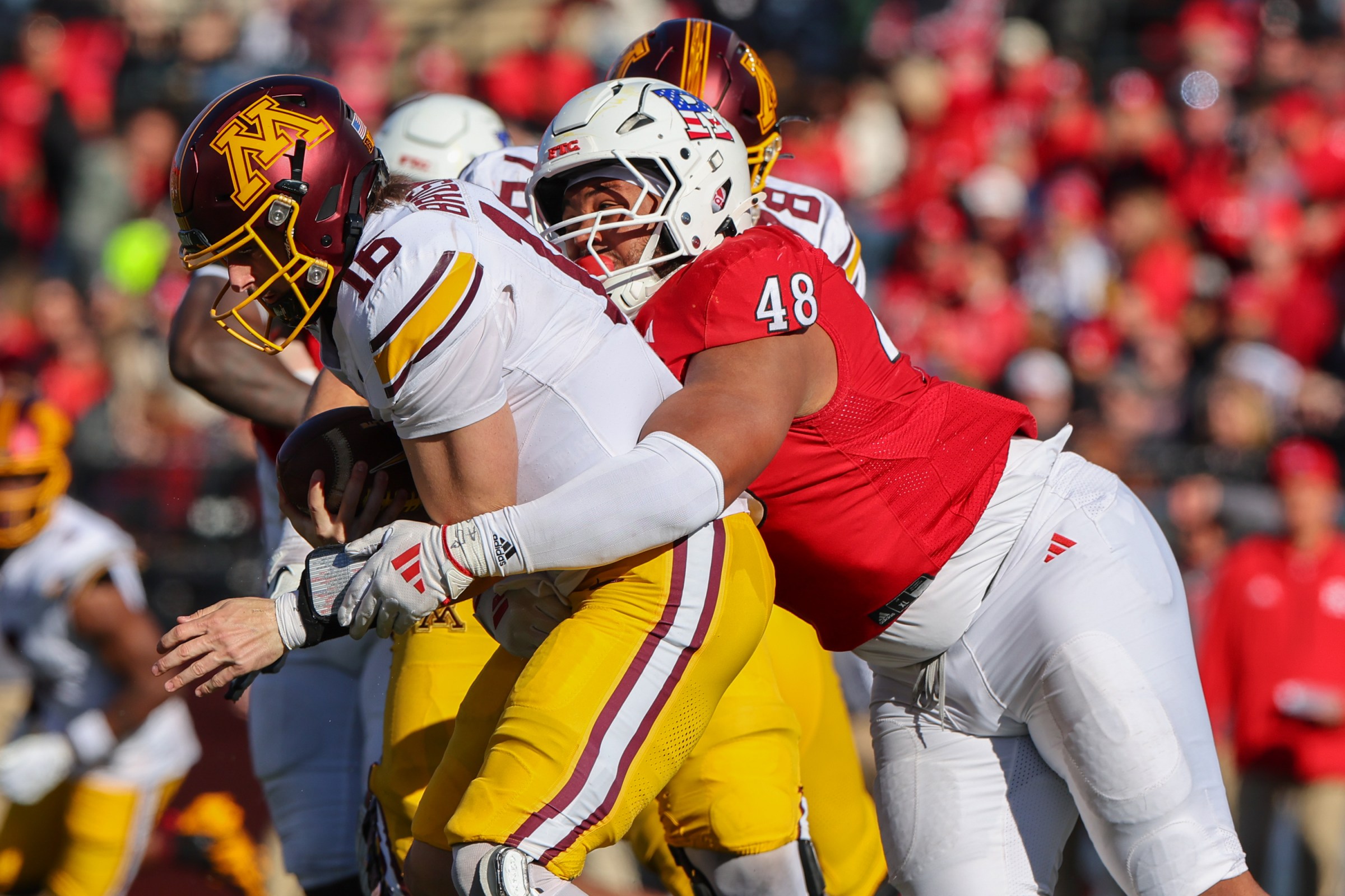 PISCATAWAY, NEW JERSEY - NOVEMBER 9: Max Brosmer #16 of the Minnesota Golden Gophers is sacked by Kyonte Hamilton #48 of the Rutgers Scarlet Knights during the first half at SHI Stadium on November 9, 2024 in Piscataway, New Jersey. (Photo by Ed Mulholland/Getty Images)