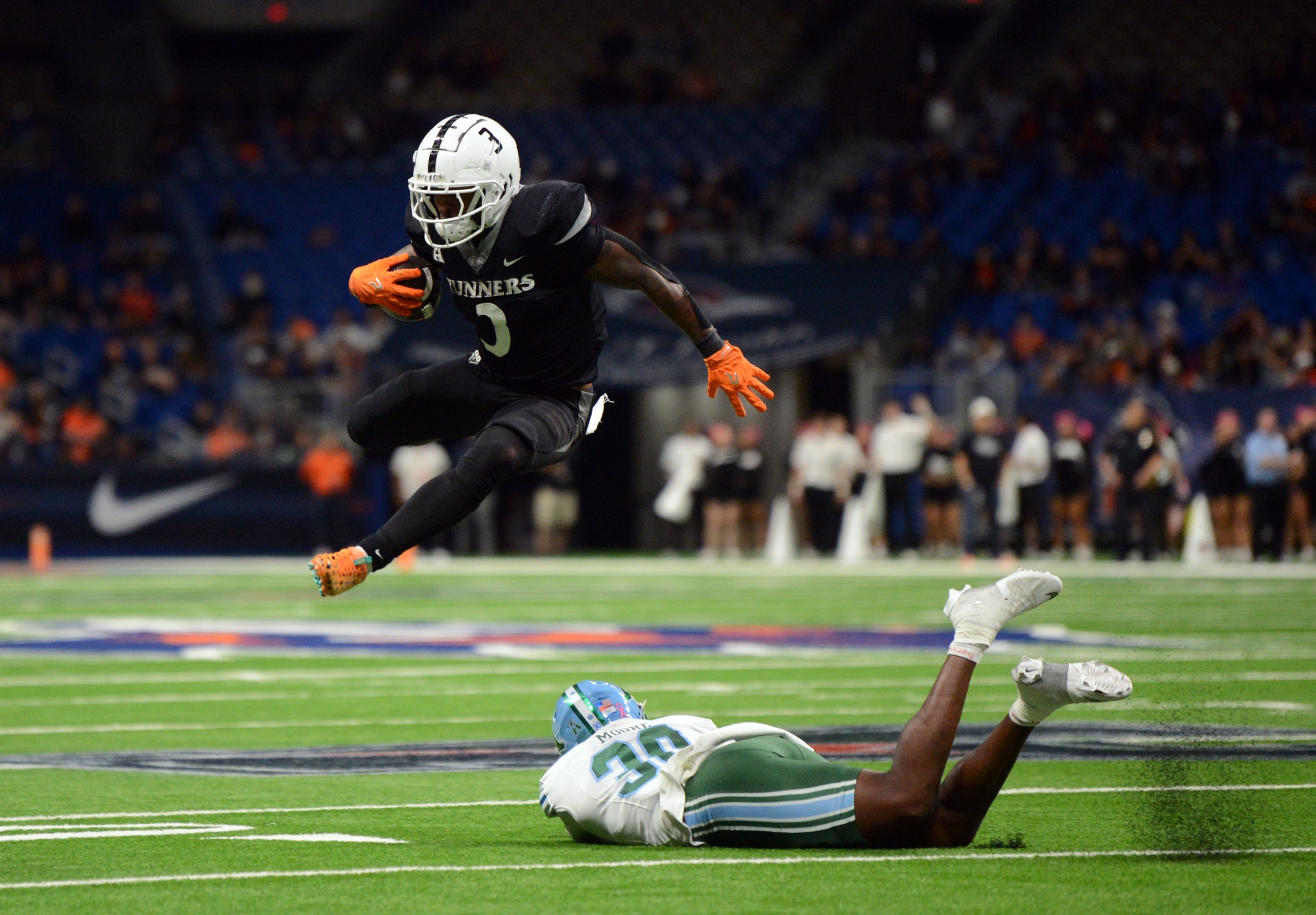 SAN ANTONIO, TX - OCTOBER 30: UTSA Roadrunners RB Robert Henry Jr. (3) leaps over Tulane Green Wave would be tackler Joshua Moore (bottom) during game between the Tulane Green Wave and the UTSA Roadrunners on October 30, 2025 at the Alamodome in San Antonio, TX. (Photo by John Rivera/Icon Sportswire via Getty Images)