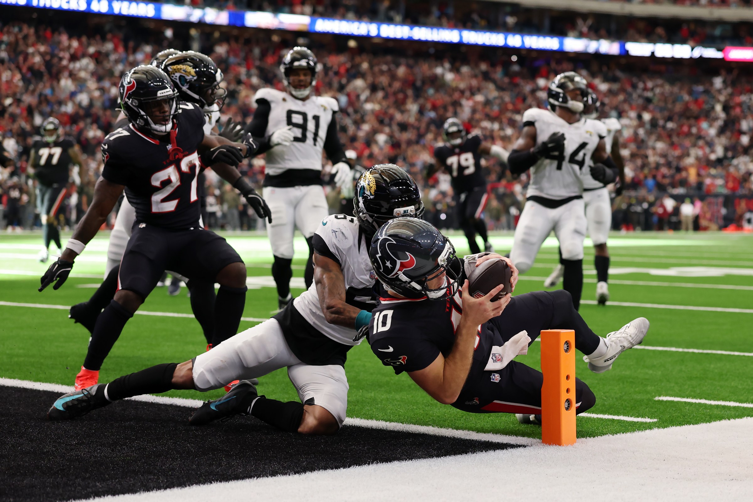 HOUSTON, TEXAS - NOVEMBER 09: Davis Mills #10 of the Houston Texans scores a rushing touchdown past Darnell Savage #6 of the Jacksonville Jaguars during the second half in the game at NRG Stadium on November 09, 2025 in Houston, Texas. (Photo by Kenneth Richmond/Getty Images)