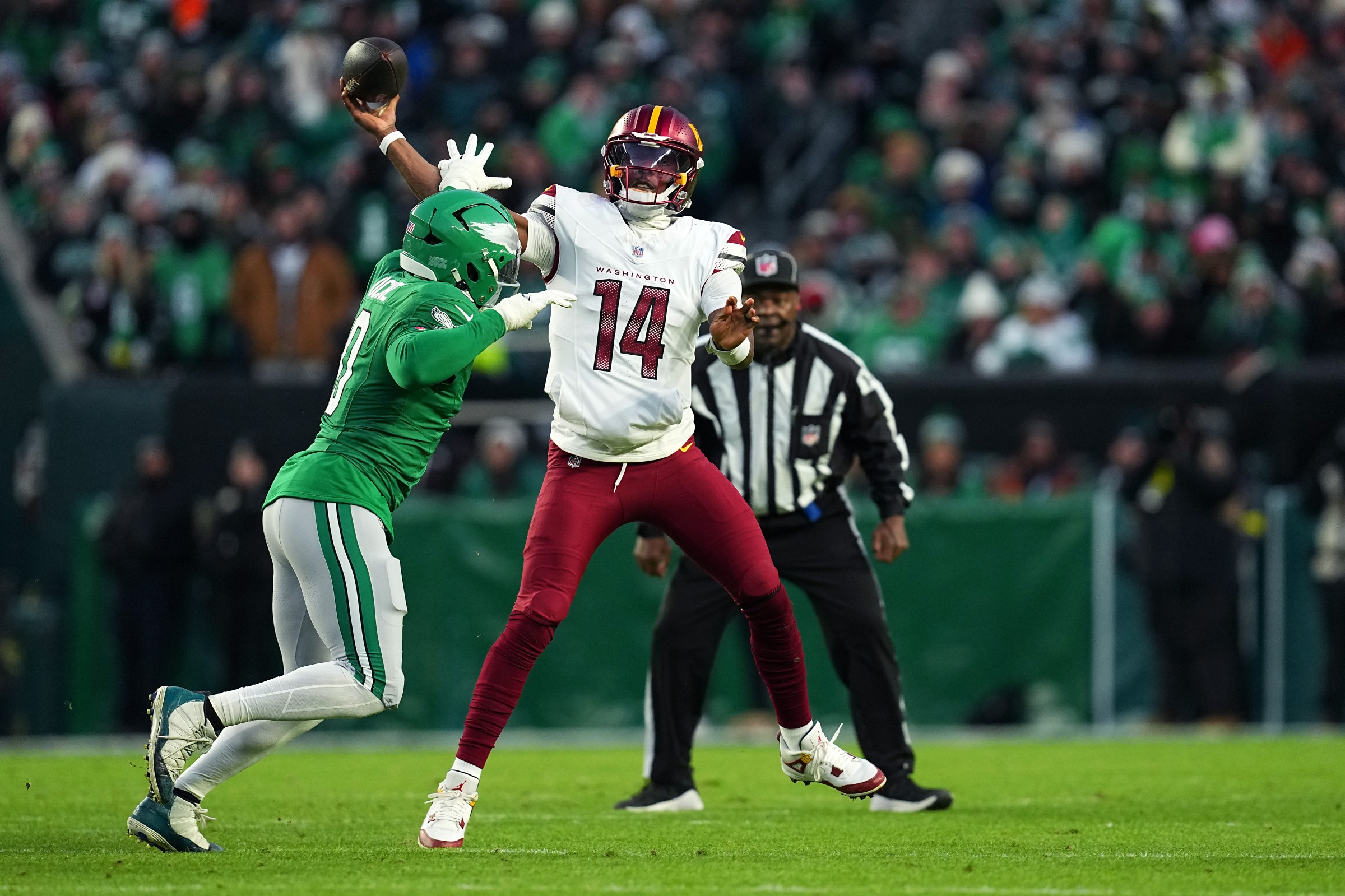 PHILADELPHIA, PENNSYLVANIA - JANUARY 04: Josh Johnson #14 of the Washington Commanders makes a pass while under pressure from Joshua Uche #0 of the Philadelphia Eagles during the first quarter of the game at Lincoln Financial Field on January 04, 2026 in Philadelphia, Pennsylvania. (Photo by Mitchell Leff/Getty Images)