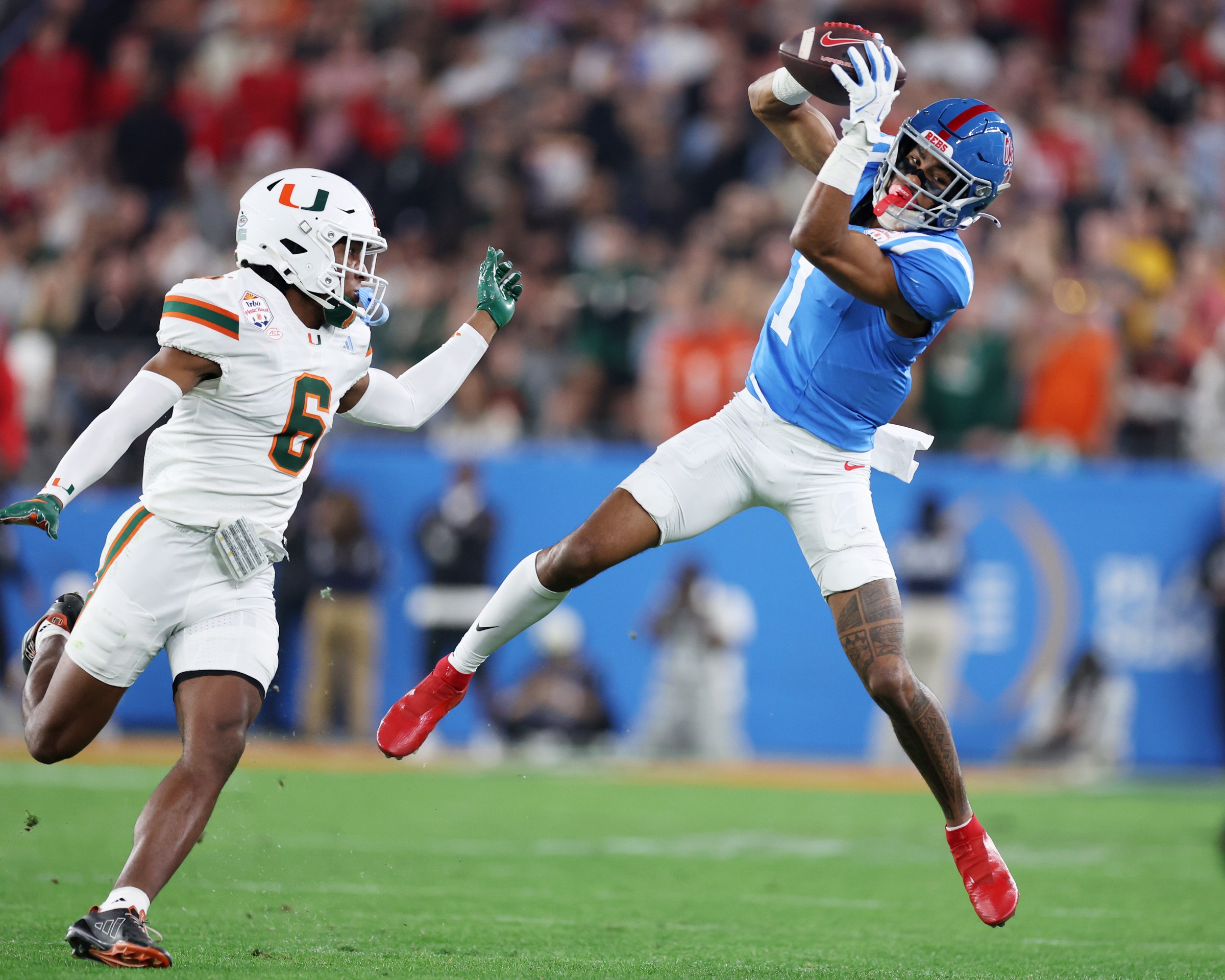 GLENDALE, ARIZONA - JANUARY 08: De’zhaun Stribling #1 of the Ole Miss Rebels makes a catch defended by Xavier Lucas #6 of the Miami Hurricanes in the third quarter during the 2025 College Football Playoff Semifinal at the VRBO Fiesta Bowl at State Farm Stadium on January 08, 2026 in Glendale, Arizona. (Photo by Chris Coduto/Getty Images)