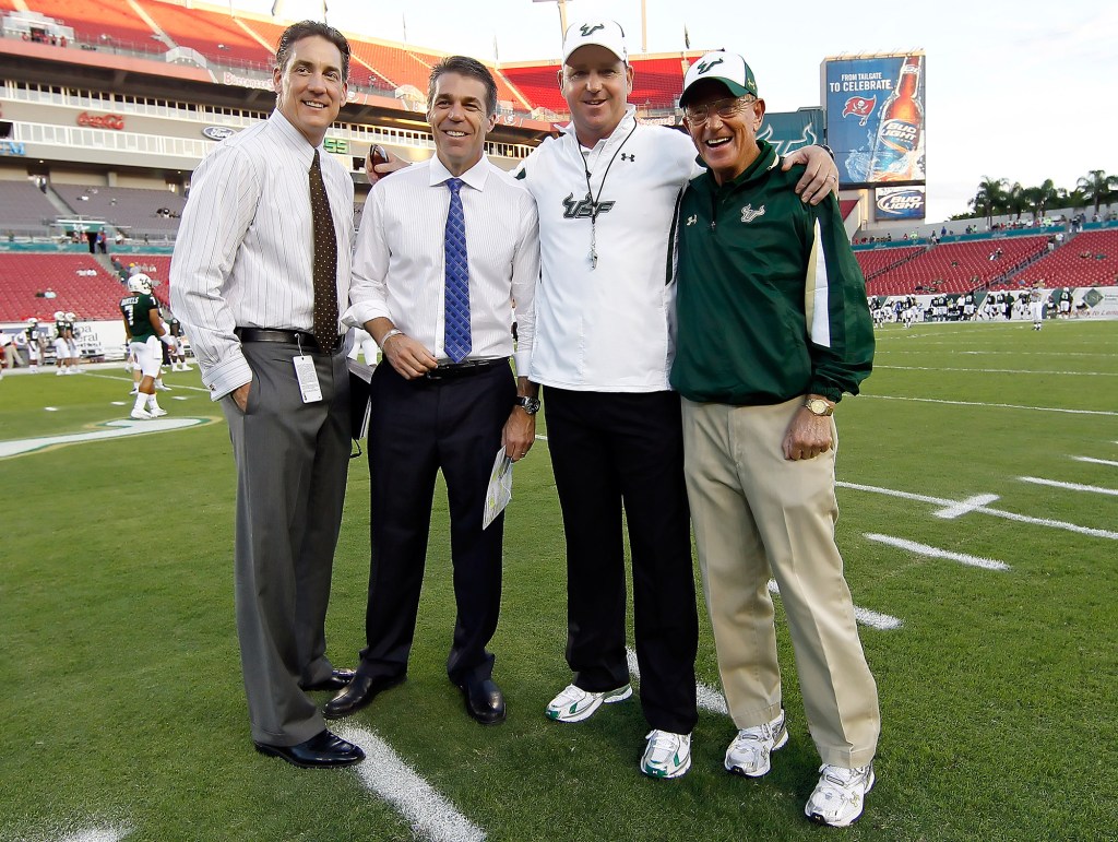 ESPN personalities Todd Blackledge (L) and Chris Fowler pose with head coach Skip Holtz and his father, Lou Holtz, in November 2010.