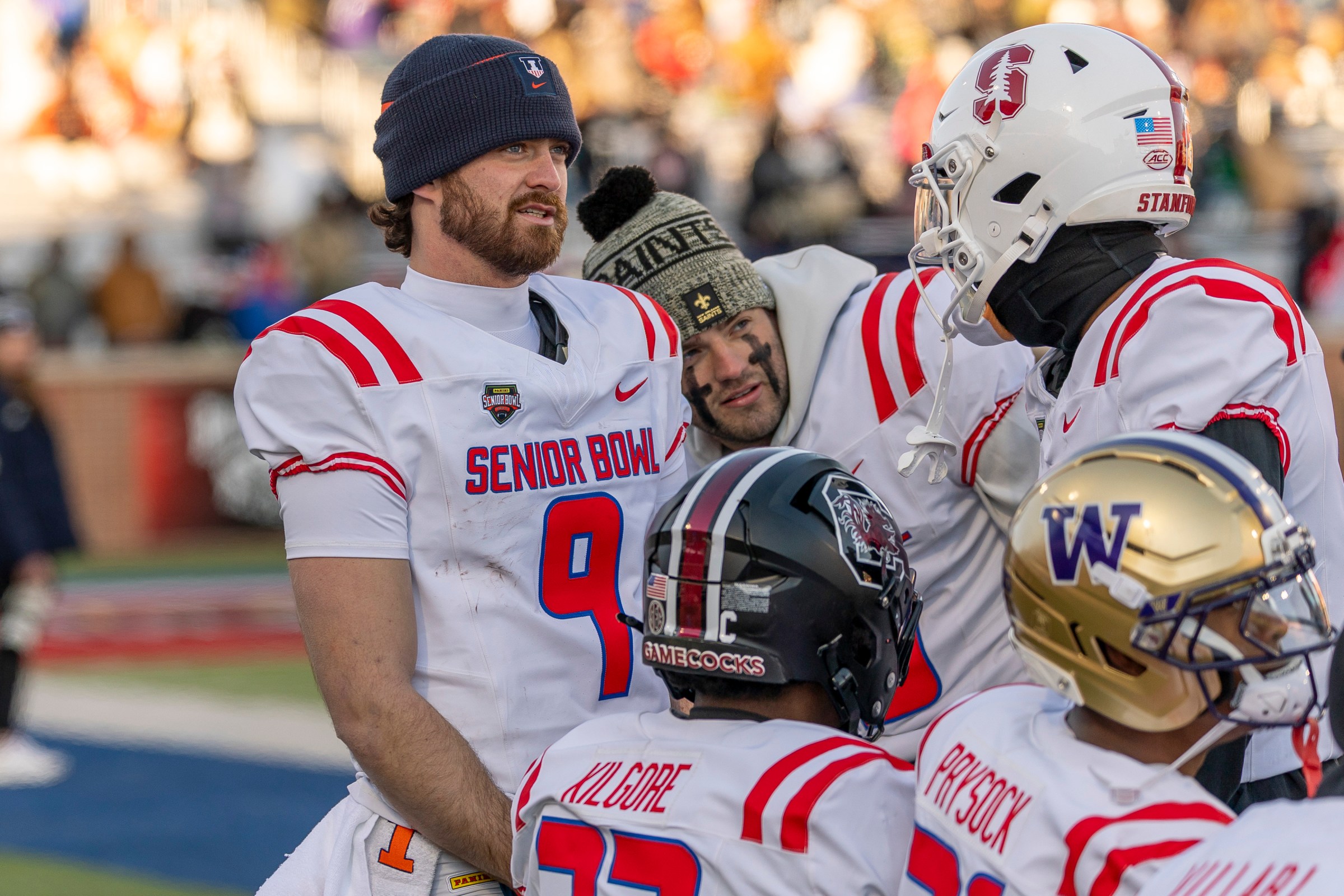 Jan 31, 2026; Mobile, AL, USA; American quarterback Luke Altmyer (9) of Illinois and American quarterback Garrett Nussmeier (13) of LSU try to stay warm in freezing weather during the second half of the 2026 Senior Bowl at University of South Alabama, Hancock Whitney Stadium. Mandatory Credit: Vasha Hunt-Imagn Images