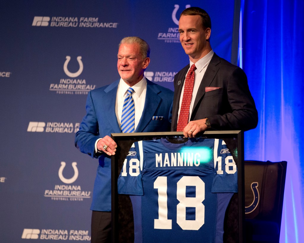 Indianapolis Colts owner Jim Irsay and former quarterback Peyton Manning pose with Manning's jersey that is being retired.
