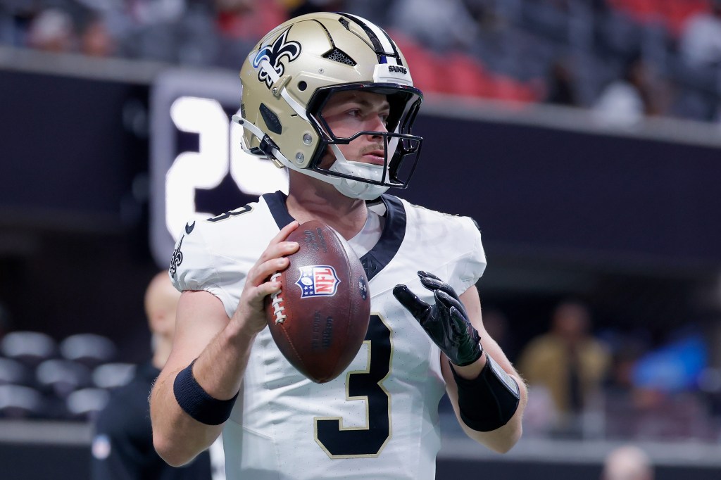 Jake Haener #3 of the New Orleans Saints warms up with an American football.