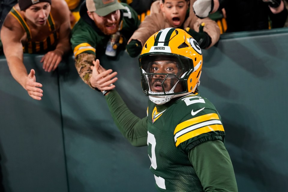 Malik Willis #2 of the Green Bay Packers celebrates with fans after scoring a touchdown in the third quarter against the Baltimore Ravens at Lambeau Field on December 27, 2025