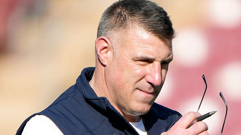 Patriots coach Mike Vrabel holds sunglasses with a pensive expression amid A.J. Brown trade rumors.