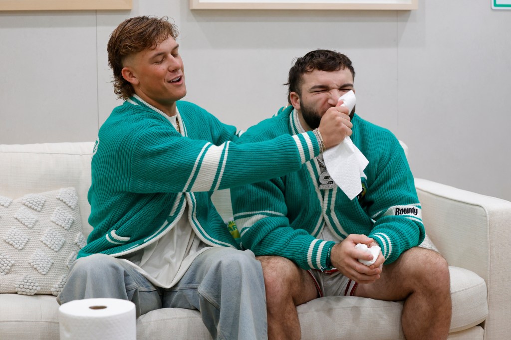 Jaxson Dart wiping Cam Skattebo's face with a Bounty paper towel.