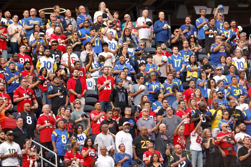 Fans wearing San Francisco 49ers and Los Angeles Rams jerseys and apparel in the stands.