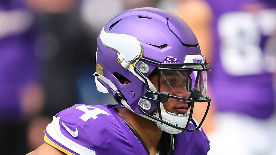 A football player in a Minnesota Vikings uniform and helmet on the field.