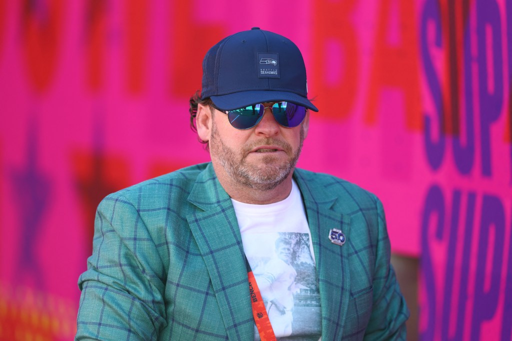 Seattle Seahawks general manager John Schneider wearing a Seahawks cap and sunglasses.