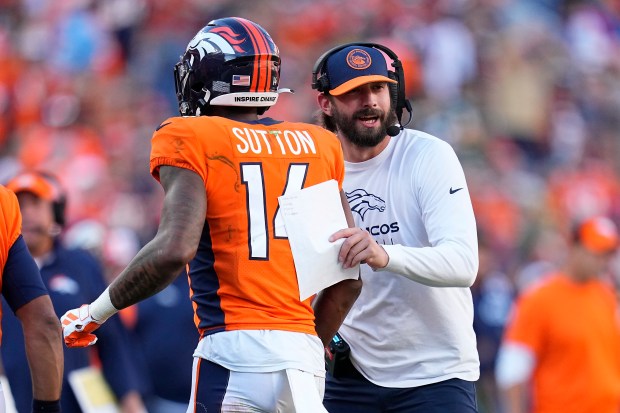 Denver Broncos wide receiver Courtland Sutton (14) is congratulated by assistant coach Davis Webb after scoring a touchdown during the second half of an NFL football game against the Green Bay Packers in Denver, Sunday, Oct. 22, 2023. (AP Photo/Jack Dempsey)