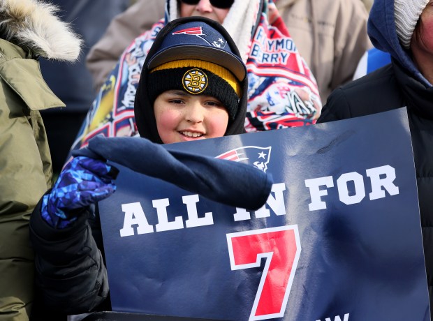 A young fan holds up a sign looking for a seventh Super Bowl trophy. (Nancy Lane/Boston Herald)