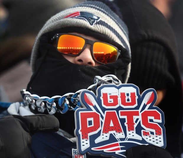 A fan wears "Go Pats" bling and a face mask against the cold during Sunday's rally. (Nancy Lane/Boston Herald)