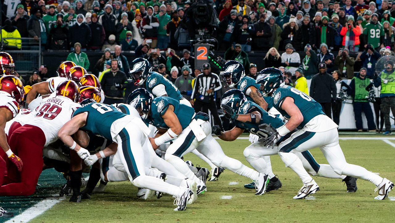Philadelphia Eagles quarterback Jalen Hurts, center, and teammates run the tush push play during the NFL championship playoff football game against the Washington Commanders, Sunday, Jan. 26, 2025, in Philadelphia