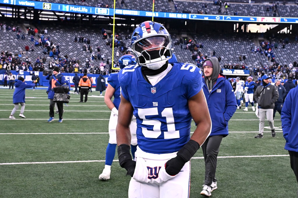 A football player in a blue jersey with the number 51 and a white facemask, looking forward on the field.