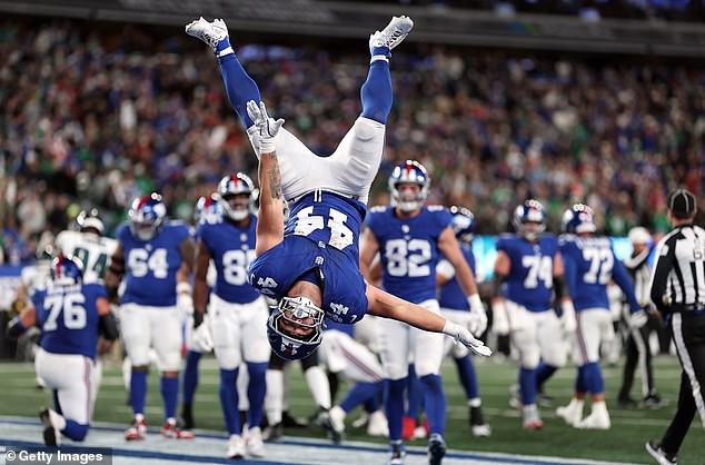 Skattebo is pictured performing a backflip to celebrate scoring a touchdown last season
